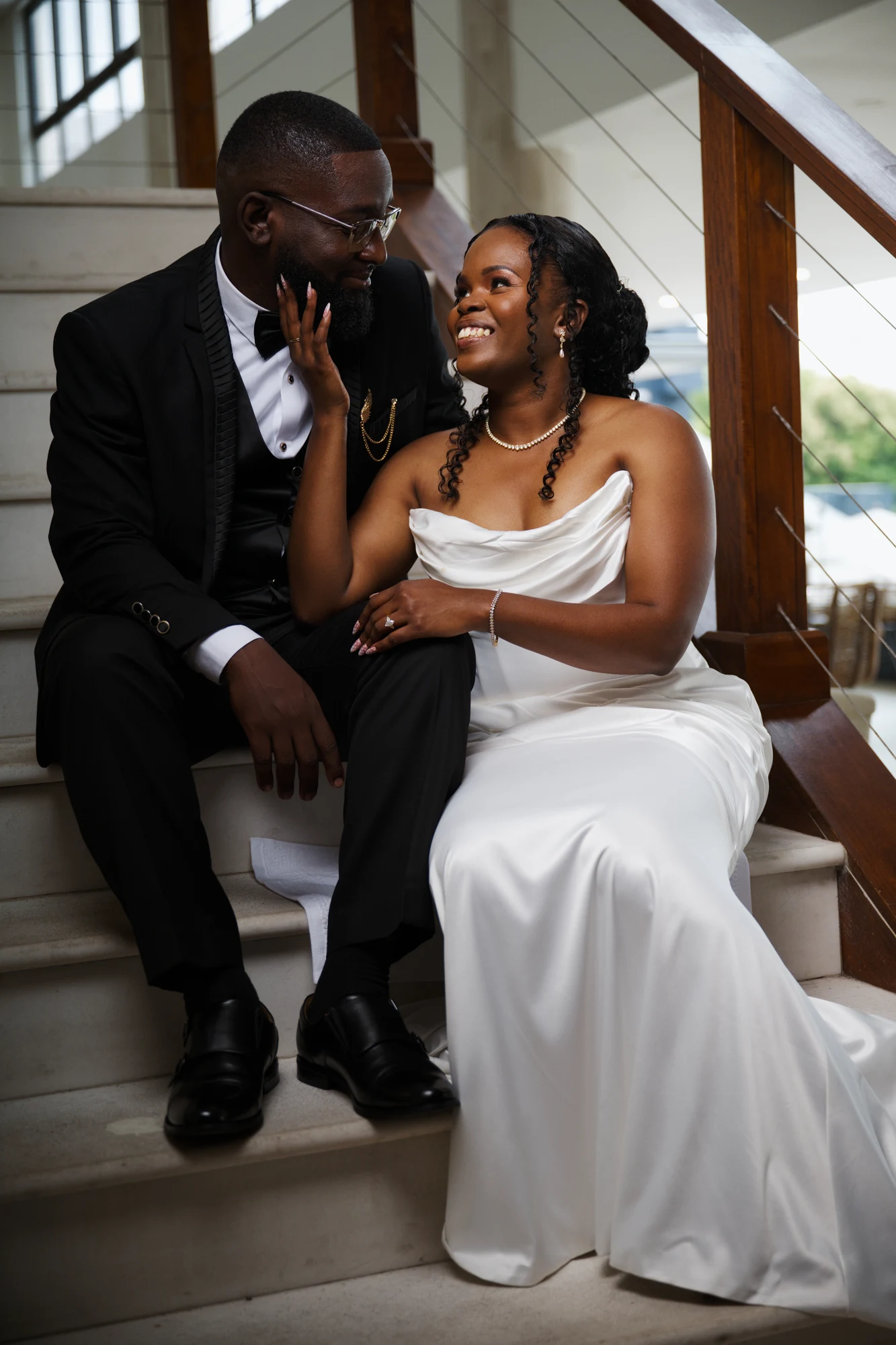 A newly married couple smiling together on a staircase
